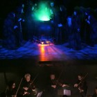 The witches stir the cauldron above the orchestra